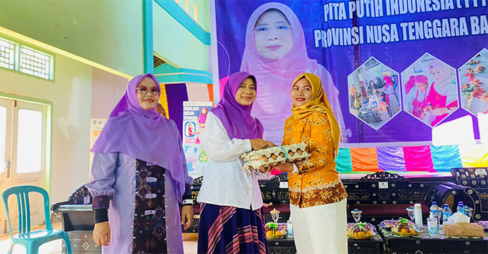 Ketua TP PKK Provinsi NTB, Hj Niken Saptarini Widyawati saat memberikan telur secara simbolis kepada salah satu orang tua anak. 