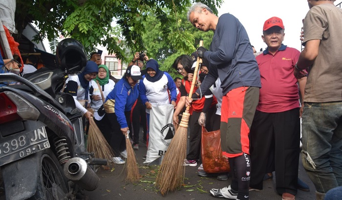 Capres nomor urut 3, Ganjar Pranowo saat blusukan ke masyarakat sembari ikut menjadi tukang sapu di jalanan. 